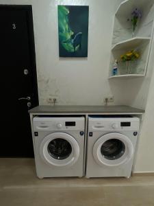 a laundry room with two washing machines and a counter at Sun and Moon in Batumi