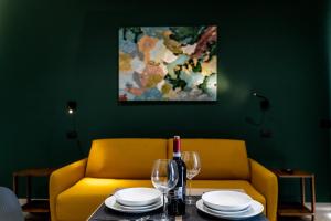 a table with a bottle of wine and a yellow couch at Virdamuri - Etna Country Resort in Giarre