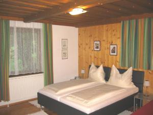 a bedroom with a large bed in front of a window at Hotel Pension Schwaiger in Sankt Margarethen im Lungau