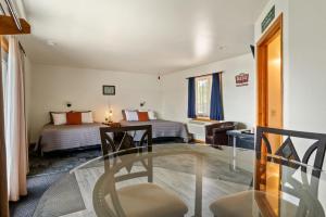 een hotelkamer met 2 bedden en een glazen tafel bij Fife Lake Lodge - Double Queen Room with Lake Access in Fife Lake