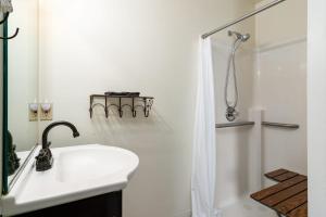 een witte badkamer met een wastafel en een douche bij Fife Lake Lodge - Double Queen Room with Lake Access in Fife Lake