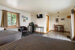 een slaapkamer met een bed, een bureau en een televisie bij Fife Lake Lodge - Double Queen Room with Lake Access in Fife Lake