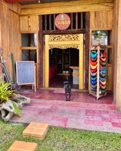 un perro negro parado en la entrada de una tienda en Chakra Tavern, en Bedugul