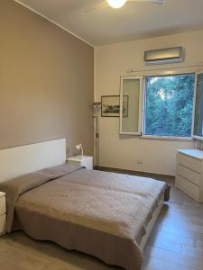 een slaapkamer met een groot bed en een raam bij La Casa di Dada in Terrasini