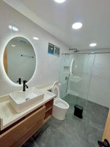 ein Badezimmer mit einem Waschbecken, einem WC und einem Spiegel in der Unterkunft Lujoso apto en laureles capacidad Max 8 personas in Medellín