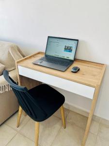 a laptop computer sitting on a desk with a chair at Costa Del Ray in Paphos City +9 photos