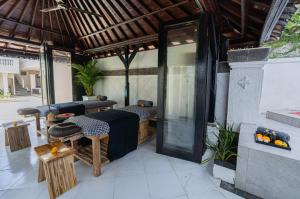 a patio with tables and chairs in a building at Casa Wina Kuta in Kuta