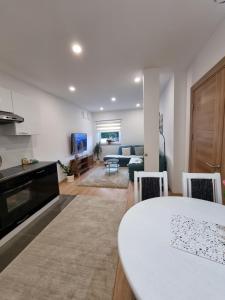 a kitchen and living room with a table and a couch at Lovely Apartment Sarajevo in Sarajevo