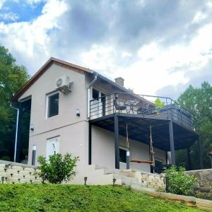 a white house with a balcony on the side of it at Mythos Private Resort in Pécs