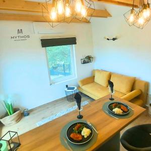 ein Wohnzimmer mit einem Tisch und Teller mit Lebensmitteln darauf in der Unterkunft Mythos Private Resort in Pécs