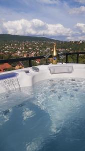 bañera de hidromasaje con copas de vino y botella en Mythos Private Resort, en Pécs