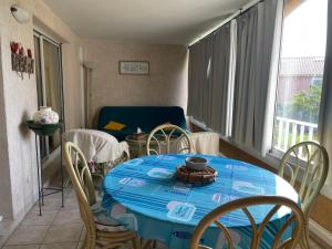 een eetkamer met een blauwe tafel en stoelen bij Appartement in La Londe-les-Maures