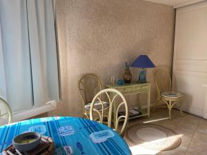 een eetkamer met een tafel en stoelen en een lamp bij Appartement in La Londe-les-Maures