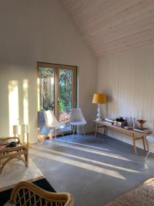 salon z krzesłami, stołem i oknem w obiekcie Nybyggd villa i mysiga Bovallstrand w mieście Bovallstrand