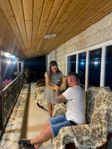 a man and a woman sitting on couches in a room at Hotel Doko in Martvili
