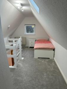 Cette chambre mansardée comprend un lit et des lits superposés. dans l'établissement FeWo Beim Museumsdorf, à Buchholz in der Nordheide