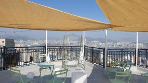 a balcony with tables and chairs and a view of the city at Mirage Yeondo Ocean view Rooftop in Busan