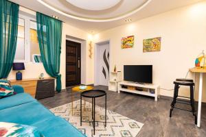 a living room with a blue couch and a tv at Modern 1BR Apartment with Private Garden Top Center in Plovdiv