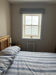 a bedroom with a bed and a window at Waterfront Apartment, St Margarets Hope, Orkney in St Margaret's Hope