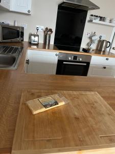 a kitchen with a wooden counter top with a book on the floor at Waterfront Apartment, St Margarets Hope, Orkney in St Margaret's Hope