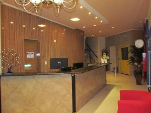 a hotel lobby with a reception counter and a clock at Hotel Bismark in São Bernardo do Campo