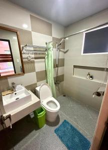 a bathroom with a white toilet and a sink at DENGI INN EL NIDO in El Nido