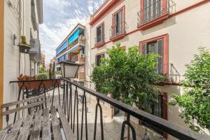 un balcón con un banco de madera en una calle en Modern & Stylish Apartment - Old Town, en Sevilla