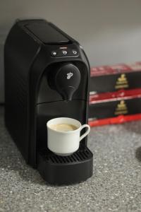 uma cafeteira está a fazer uma chávena de café em S1 Apartman em Szombathely