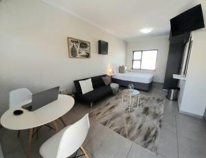 a living room with a couch and a table with a laptop at Downwind - Visit Langebaan in Langebaan +14 photos