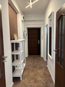 a hallway with a white shelf and a door at S1 Apartman in Szombathely