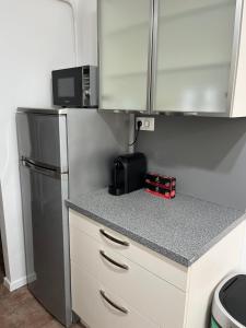 a small kitchen with a refrigerator and a microwave at S1 Apartman in Szombathely +5 photos