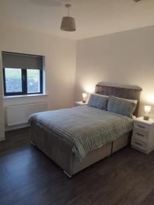 a bedroom with a bed and a window and two lamps at Stable Hill House in Killarney