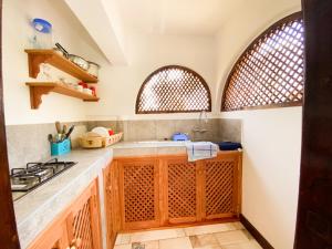 - une cuisine avec un évier et 2 fenêtres dans l'établissement 611 Sporting Residence, à Malindi