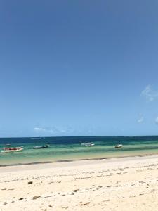 une plage avec plusieurs bateaux dans l'eau dans l'établissement 611 Sporting Residence, à Malindi