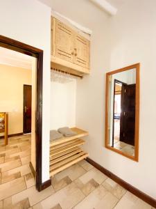 een kamer met een spiegel aan de muur en een aanrecht bij 611 Sporting Residence in Malindi