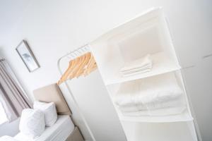 Spacious 5 Bedroom House - Sleeps 7 - 3-Car Driveway - Work - Leisure في ولفرهامبتون: ثلاجة بيضاء فيها مناشف بيضاء
