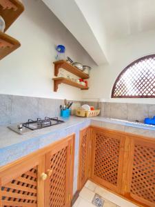 een keuken met houten kasten en een wastafel bij 611 Sporting Residence in Malindi