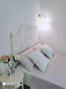 - un lit blanc avec des oreillers et une table avec une lampe dans l'établissement Apartman Legac 2 Nin, à Nin