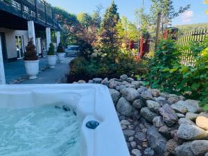 una vasca da bagno in un cortile con rocce di Le Coq Heureux a Vånga