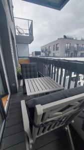 - un balcon avec un banc, une table et des chaises dans l'établissement Apartament Mokotów/Taśmowa 6, à Varsovie