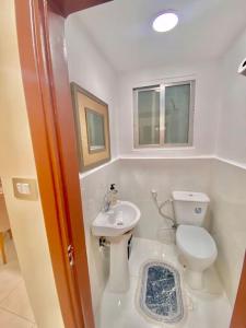 a small bathroom with a toilet and a sink at Great location apartment in Amman