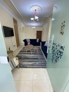 un soggiorno con divano blu e tavolo di Great location apartment ad Amman