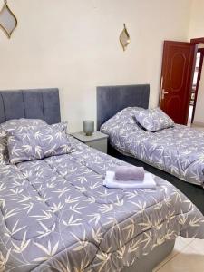two beds sitting next to each other in a bedroom at Great location apartment in Amman