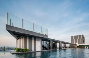 - un bâtiment avec une piscine au-dessus de l'eau dans l'établissement The Base Central Pattaya by Adam, à Pattaya