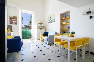 - un salon avec une table blanche et des chaises jaunes dans l'établissement DEA APARTMENT, à Rapallo