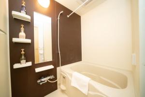 a bathroom with a tub and a sink and a mirror at shinjuku1 in Tokyo