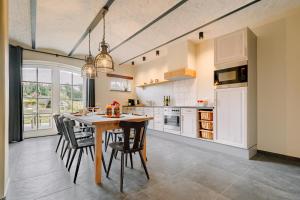 cocina con mesa de madera y sillas en BuitenGewoon Libeek, en Sint Geertruid