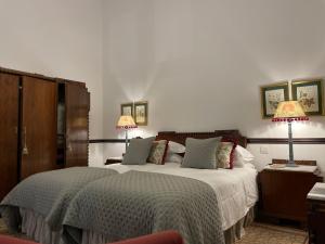 a bedroom with a large bed with two lamps at Casa Colonial El Indiano in Las Palmas de Gran Canaria