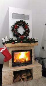 una chimenea con una corona de Navidad encima en Cabana All Seasons en Cavnic