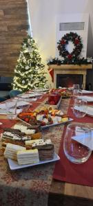 einen Tisch mit Speise- und Weingläsern und einen Weihnachtsbaum in der Unterkunft Cabana All Seasons in Cavnic